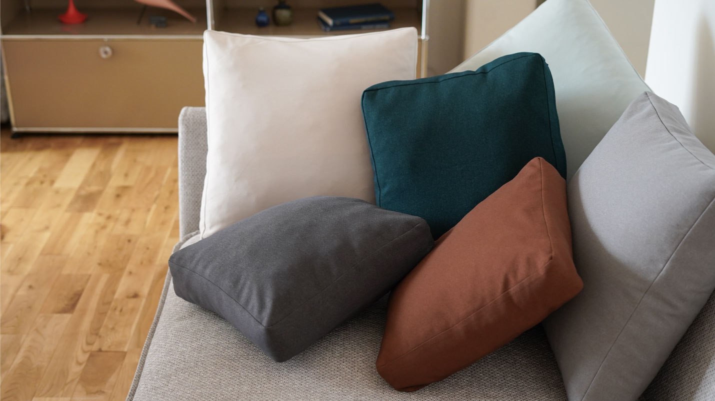 フランネルソファでたくさんのサンドイッチクッションに包まれて